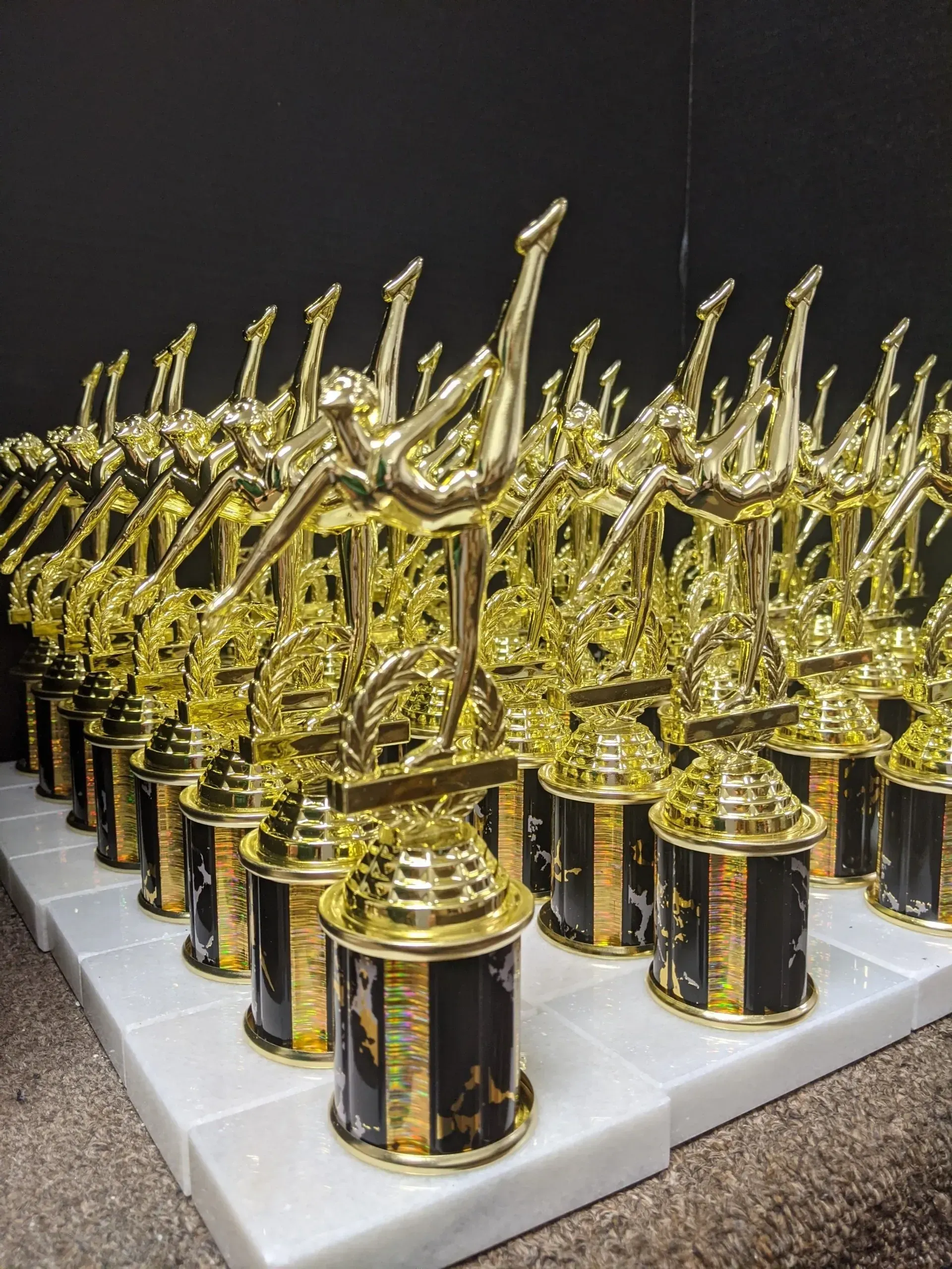 A bunch of trophies are lined up on a table