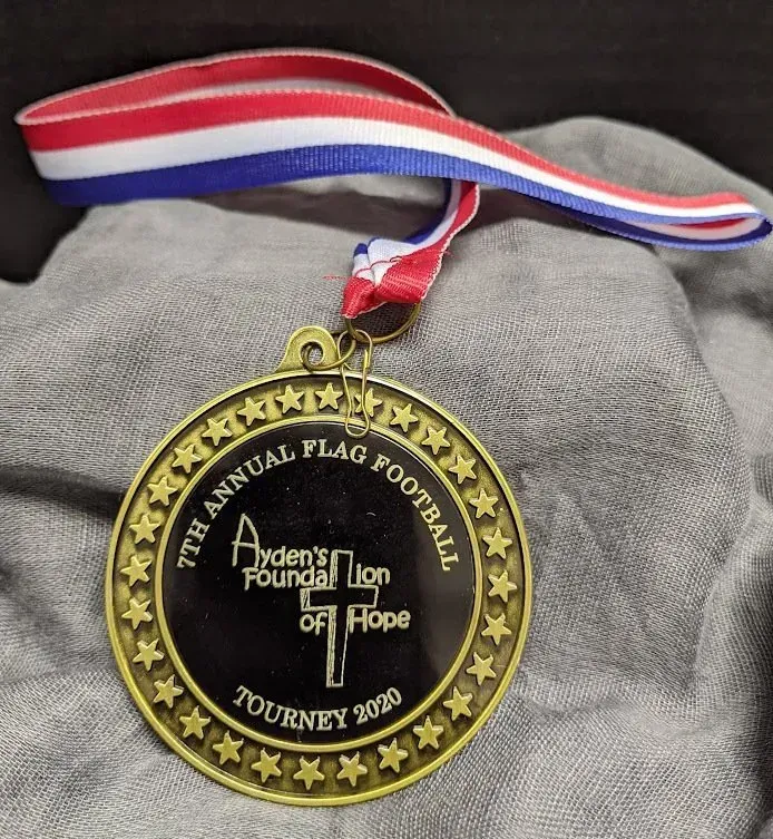 A medal from the 7th annual flag football tourney