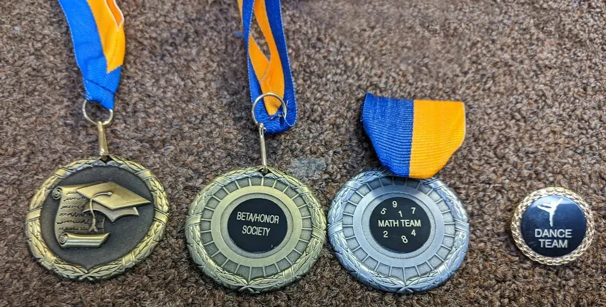A group of medals sitting on top of a brown carpet.