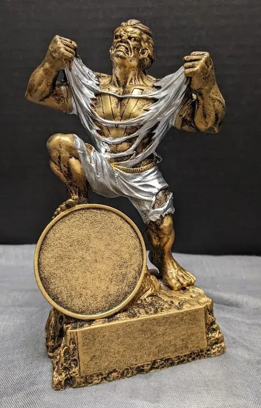 A gold and silver statue of a man holding a medal.
