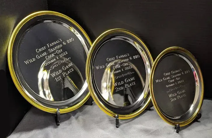 Three silver plates with gold rims are sitting on a table.