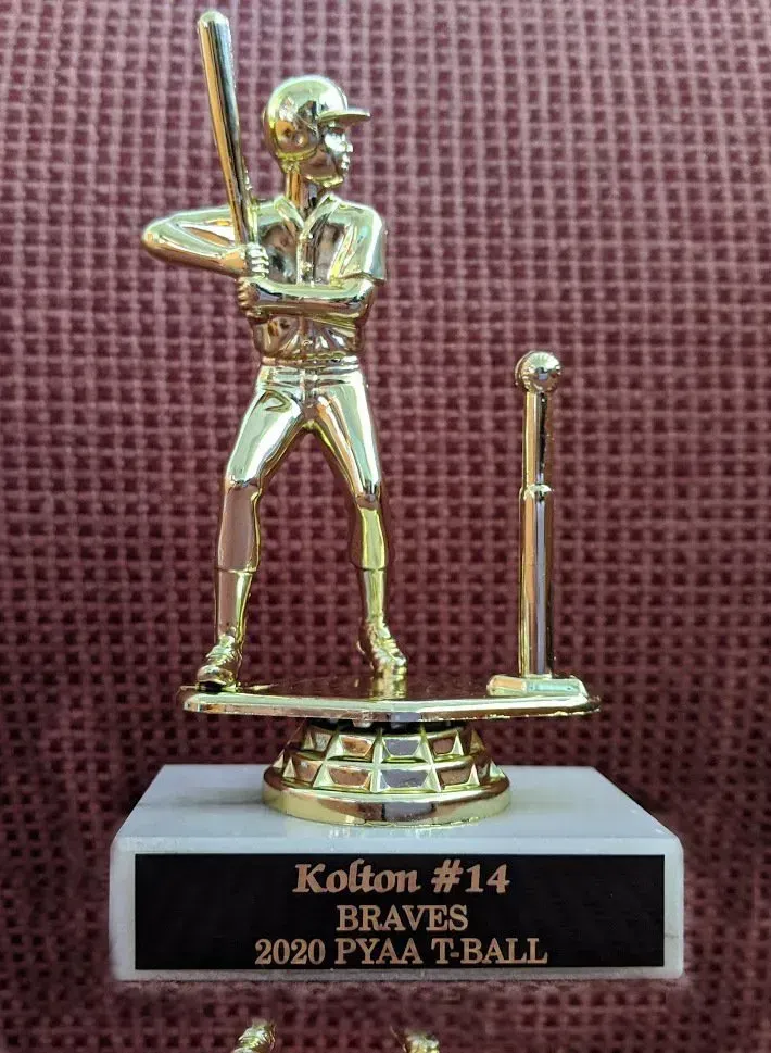 A gold trophy of a baseball player holding a bat.