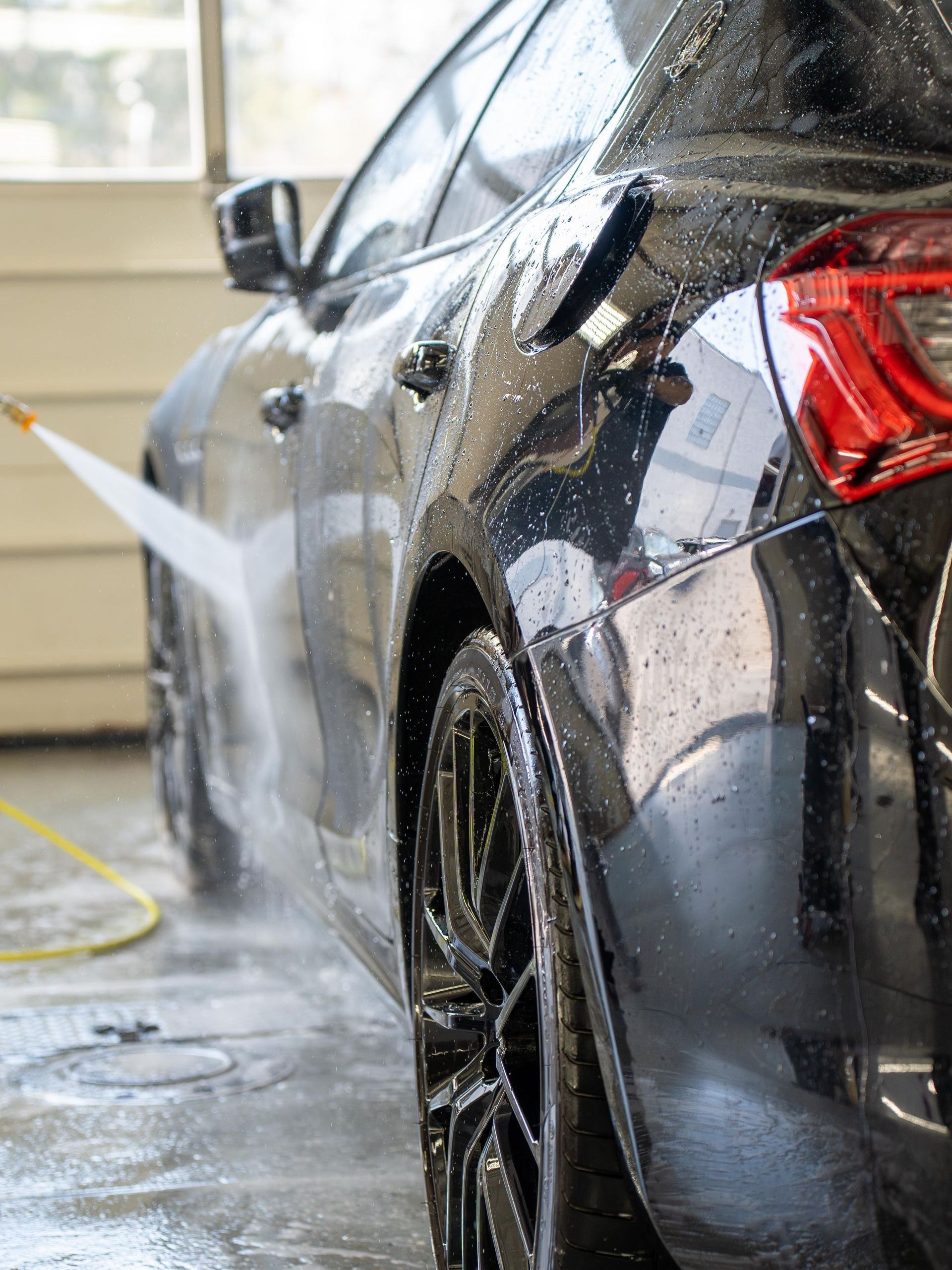 A tesla cybertruck is covered in foam in front of a building.
