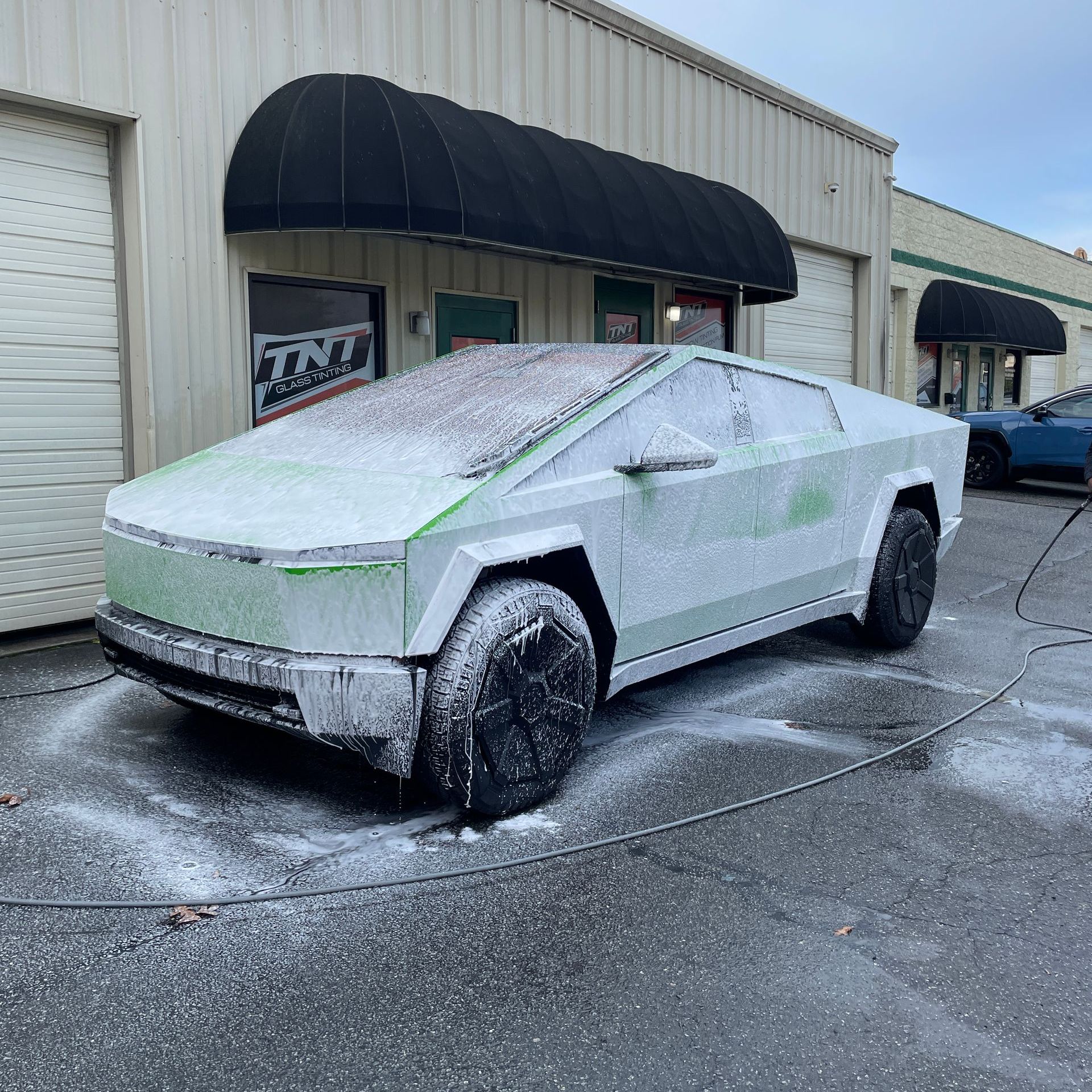 A person is washing a car with a sponge.