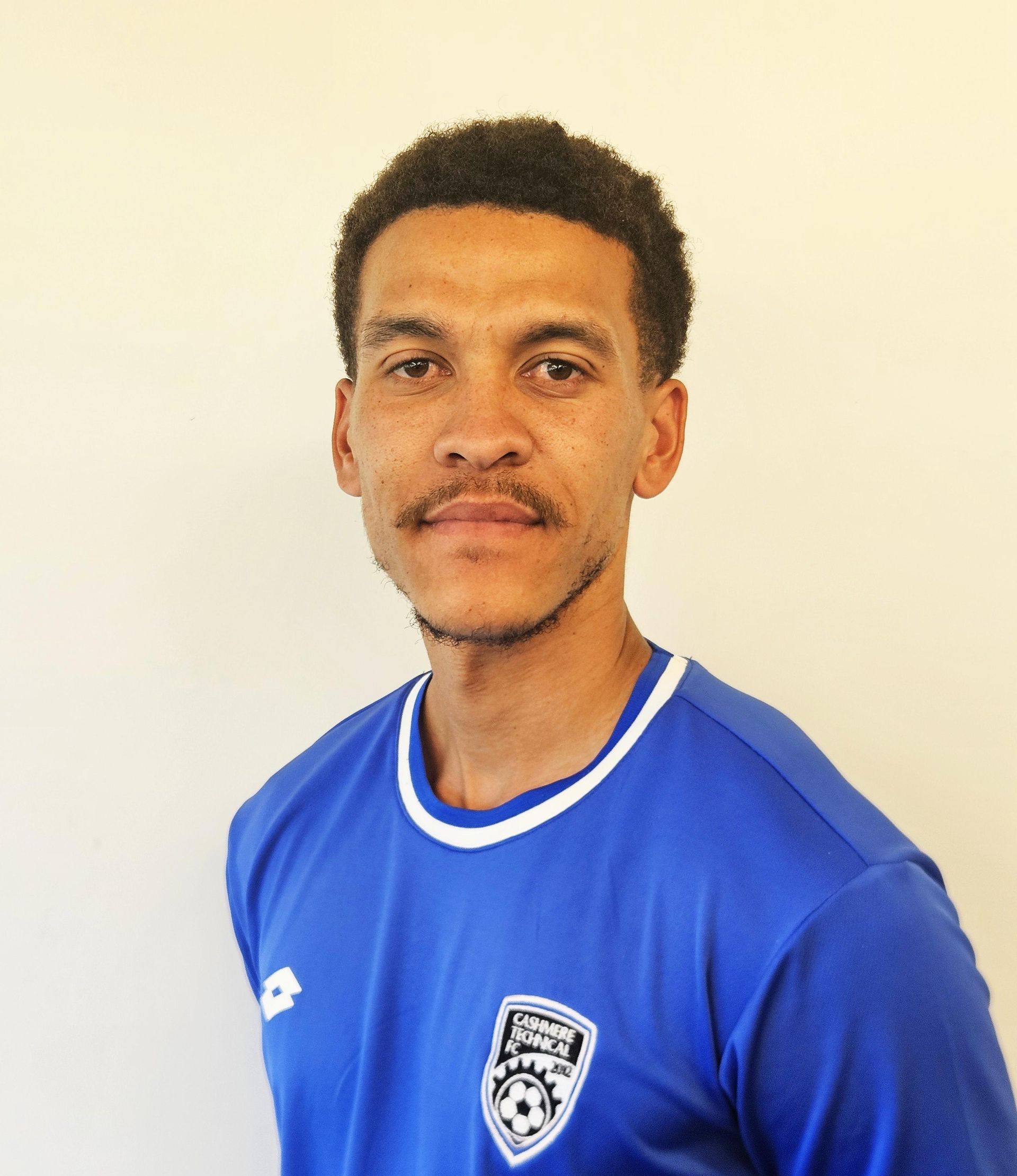 A man wearing a blue shirt with a soccer ball on it