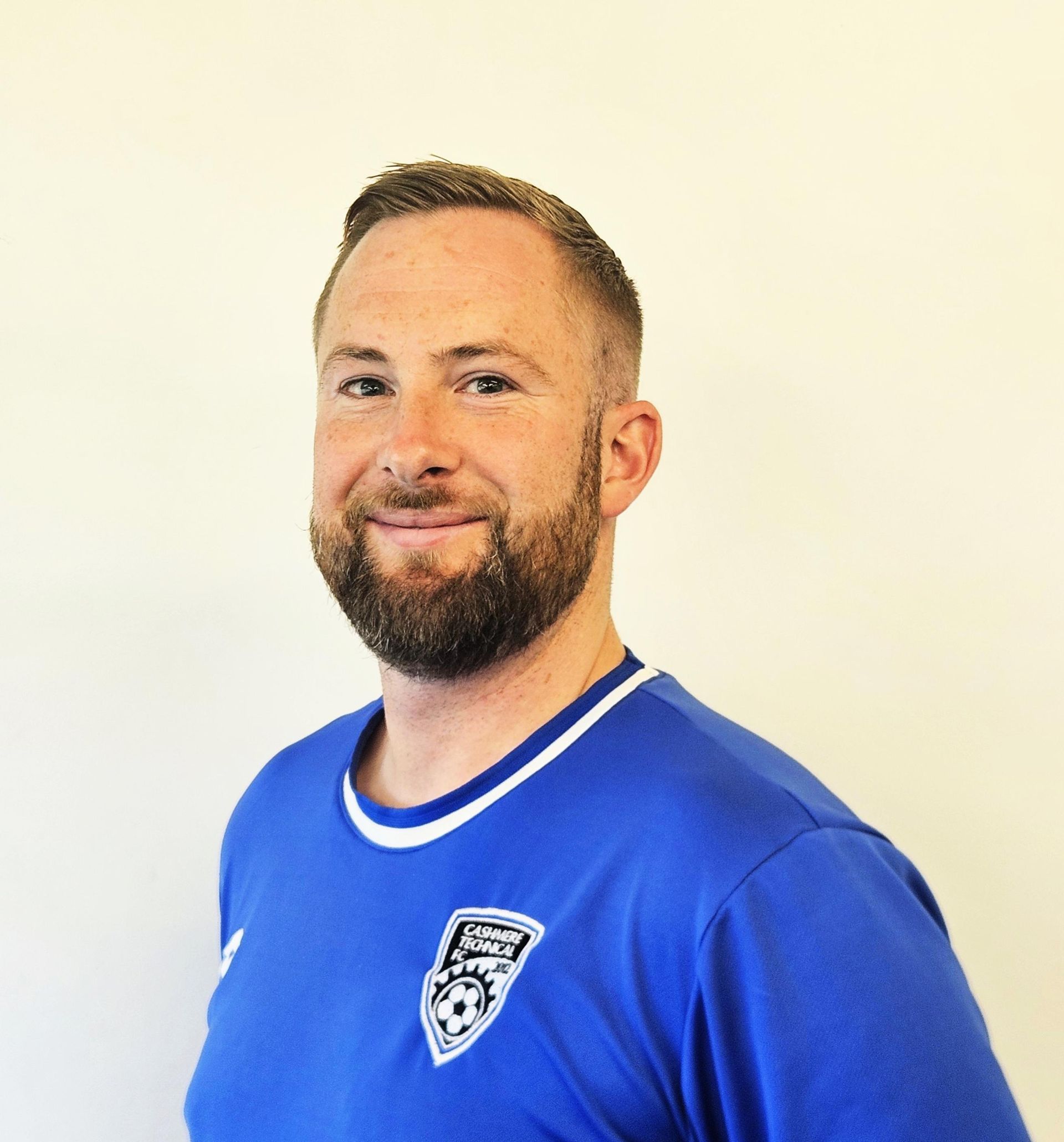 A man with a beard is wearing a blue shirt with the number 5 on it