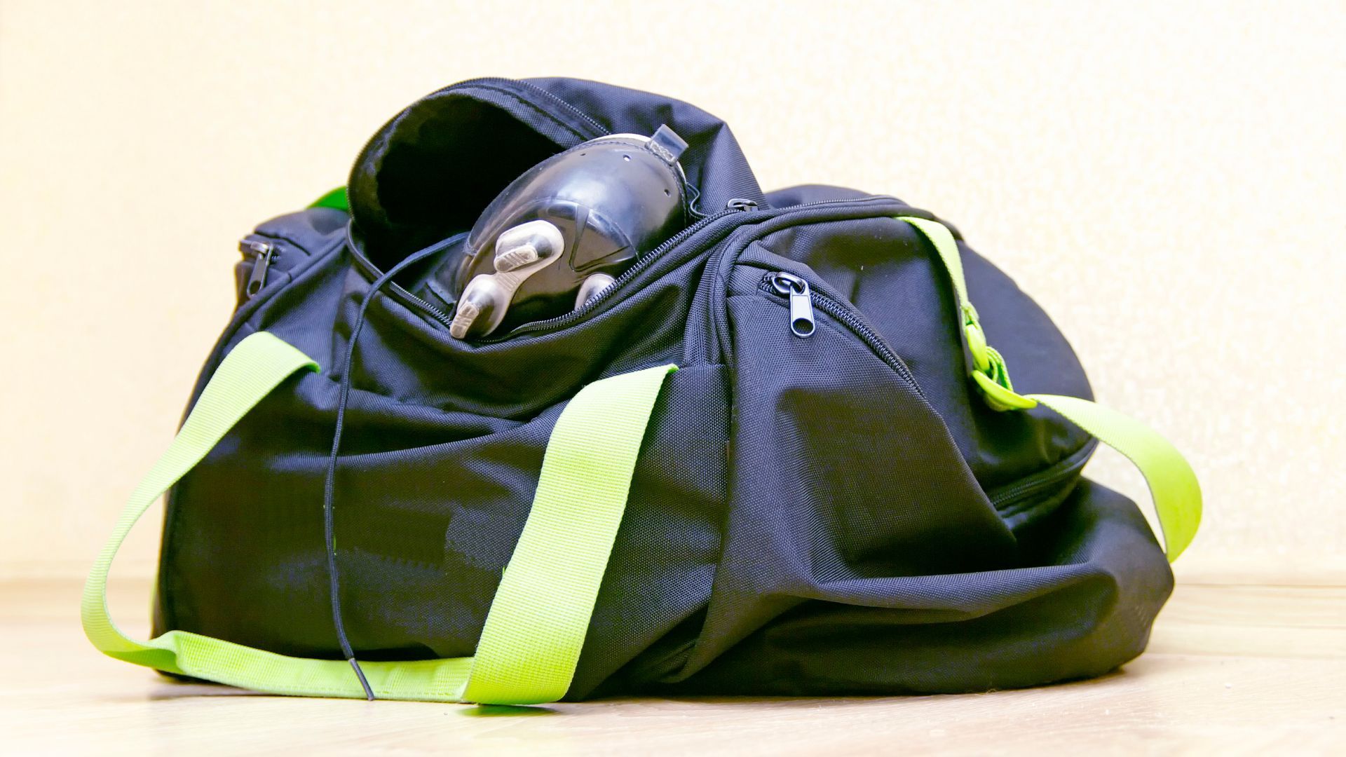 A black duffel bag with a pair of headphones in it