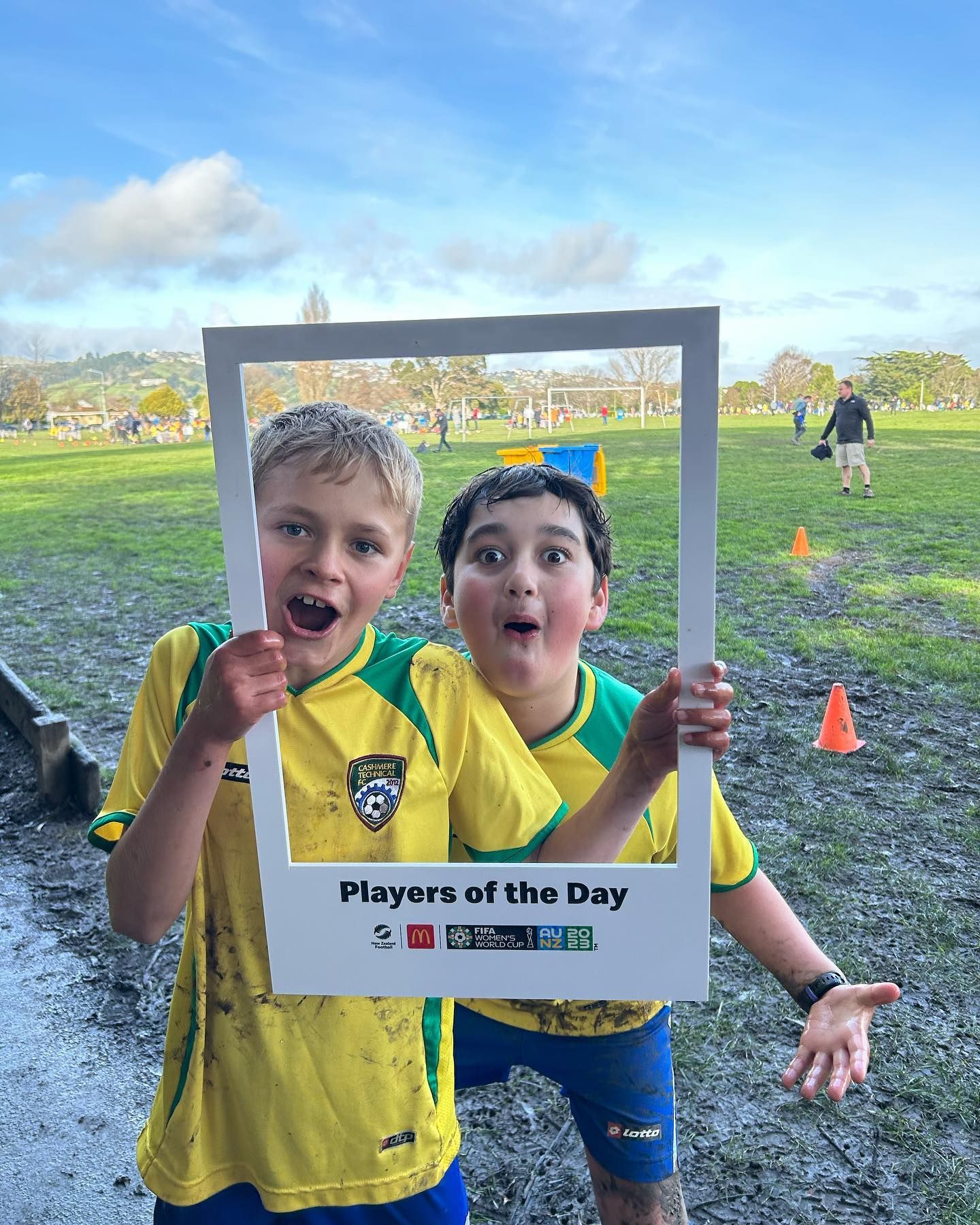 Two young boys are holding a picture frame that says players of the day.