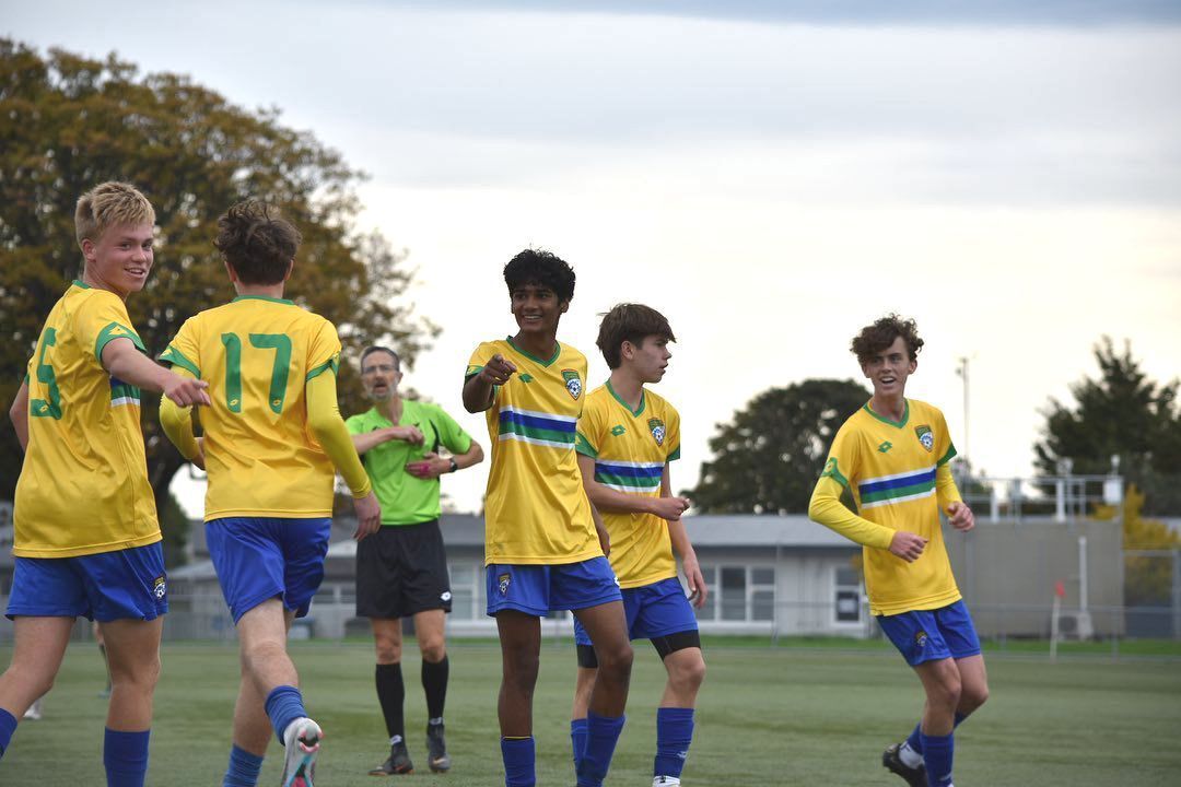 A group of young men are playing soccer on a field.