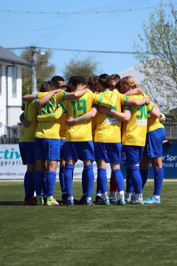 A group of soccer players are huddled together on a field.