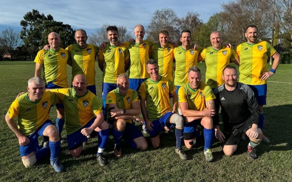 A group of children are playing soccer on a field.