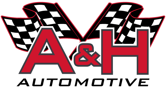 A logo for a & h automotive with checkered flags