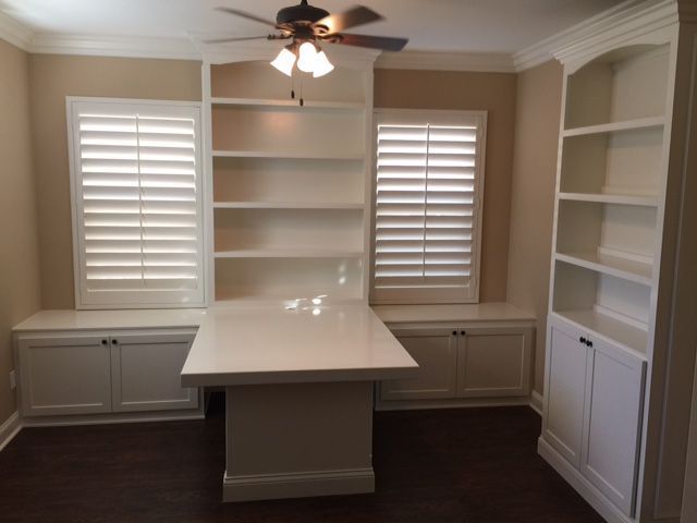 A room with lots of shelves and a ceiling fan