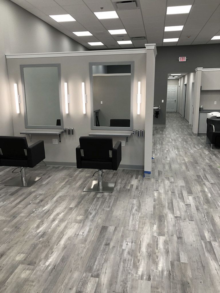 A large room with a lot of chairs and mirrors in a salon