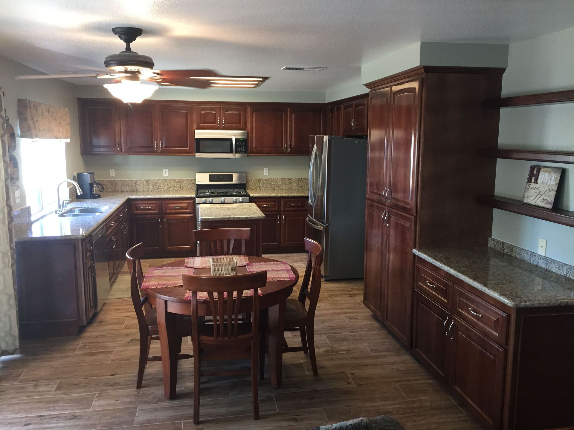 A kitchen with a table and chairs and a ceiling fan