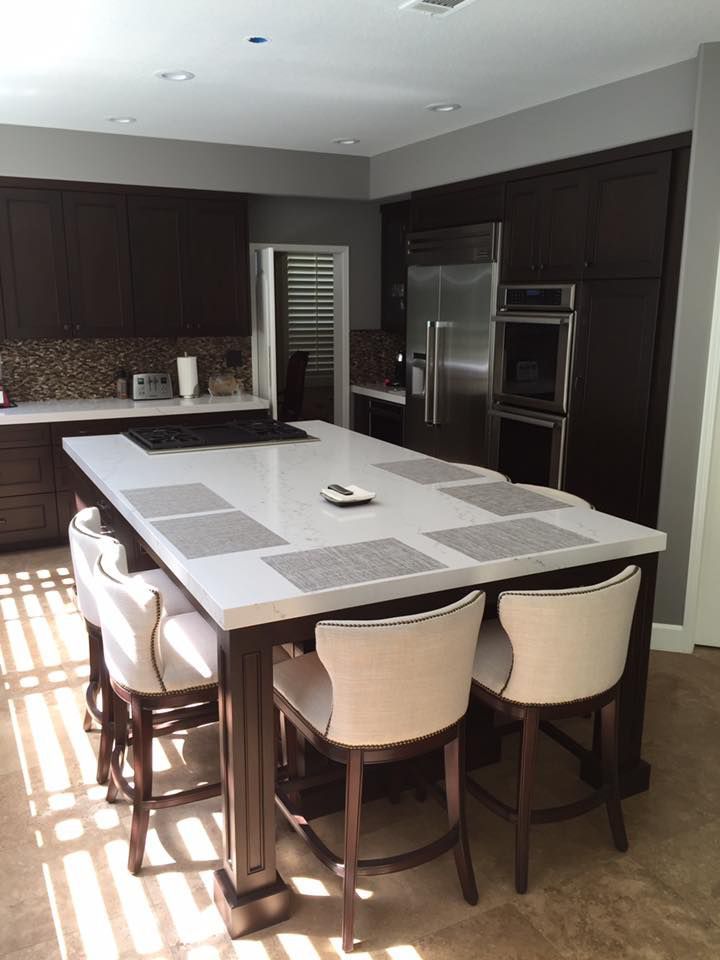 A kitchen with a large island and chairs