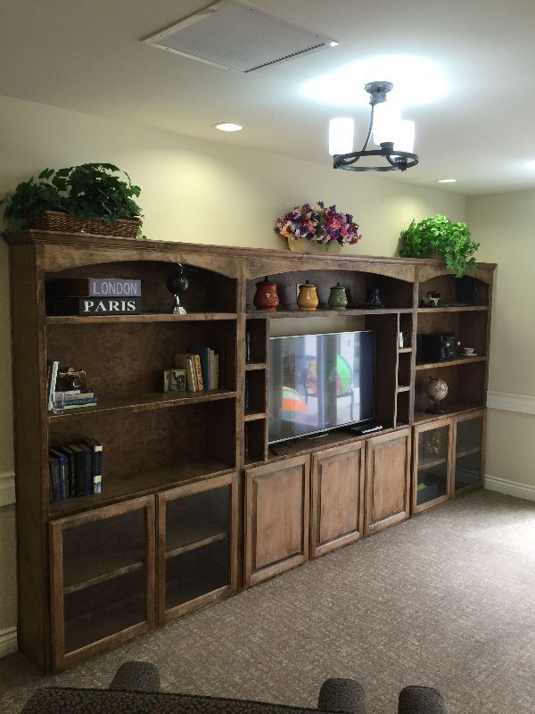 A living room with a large entertainment center and a sign that says paris