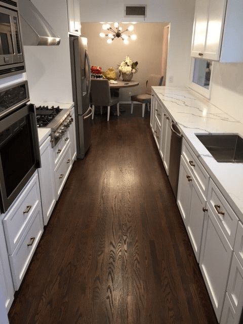 A kitchen with white cabinets and stainless steel appliances
