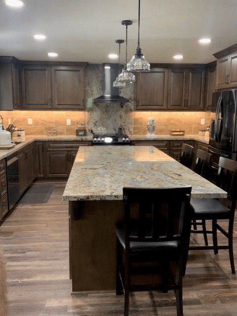 A kitchen with a large island and a stove top oven