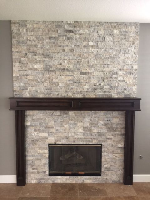 A fireplace with a brick wall and a mantle in a living room