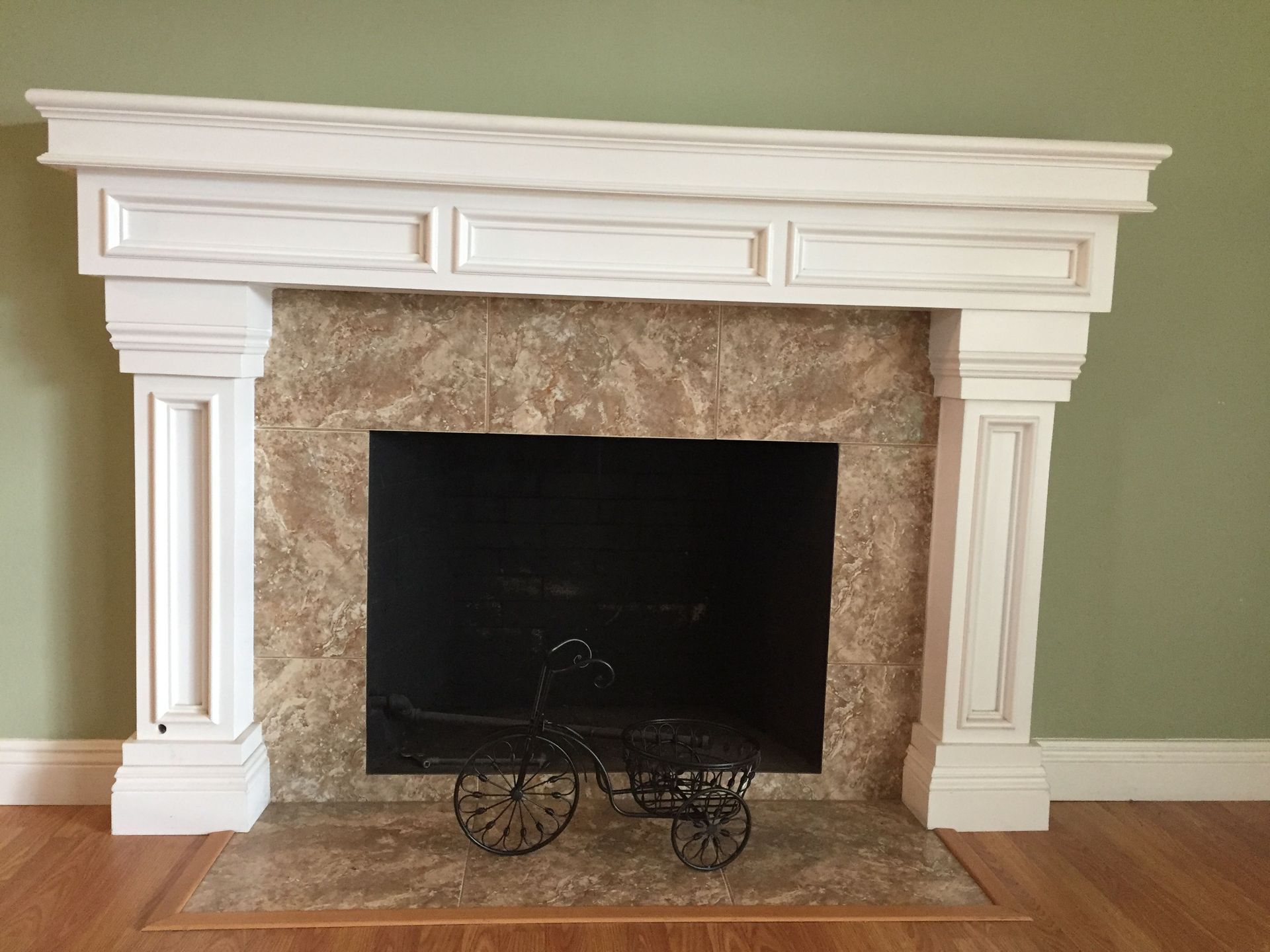A fireplace with a white mantle and a black screen