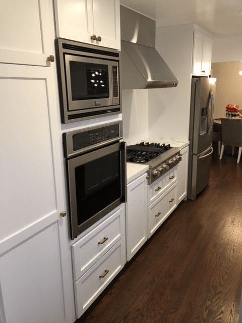 A kitchen with white cabinets and stainless steel appliances