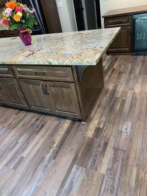 A kitchen island with a vase of flowers on top of it
