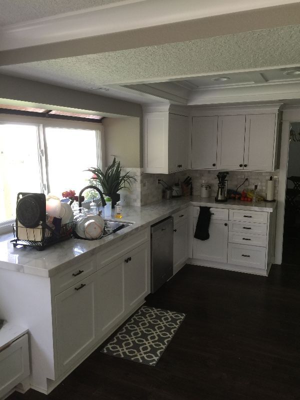A kitchen with white cabinets and stainless steel appliances