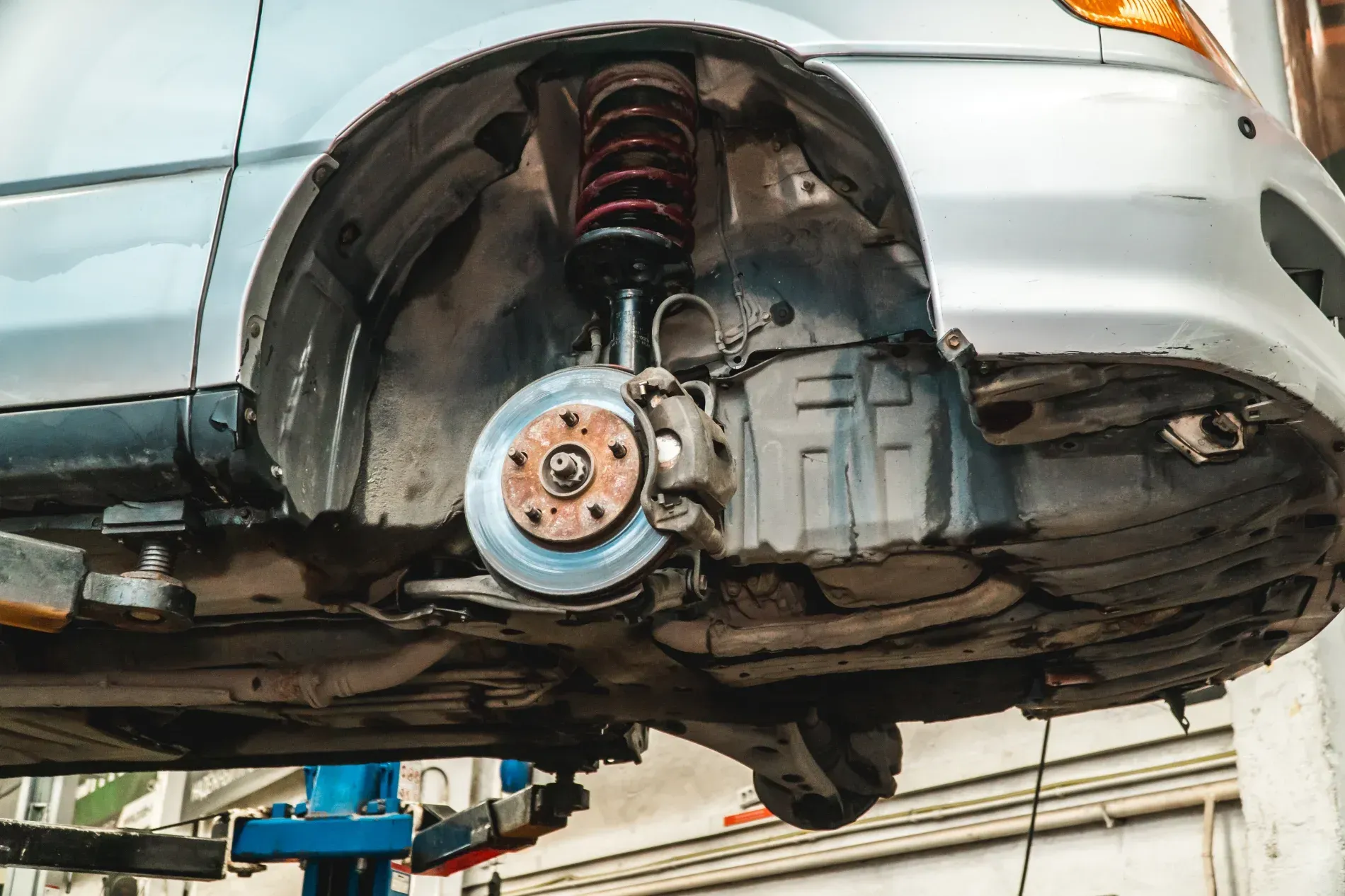 Car Lifted on a Hoist, Exposing the Wheel Well and Suspension in a Repair Shop — Forster Smash Repairs in Forster, NSW
