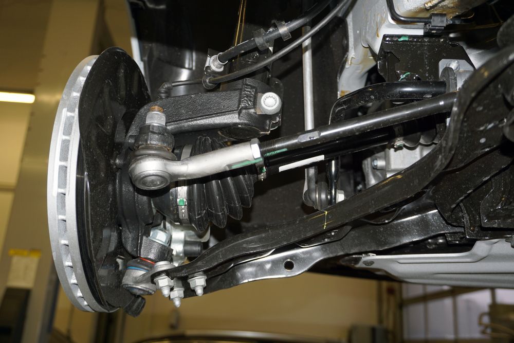 Close-up of a Car’s Front Suspension and Brake Assembly With a Silver Wheel Hub — Forster Smash Repairs in Forster, NSW