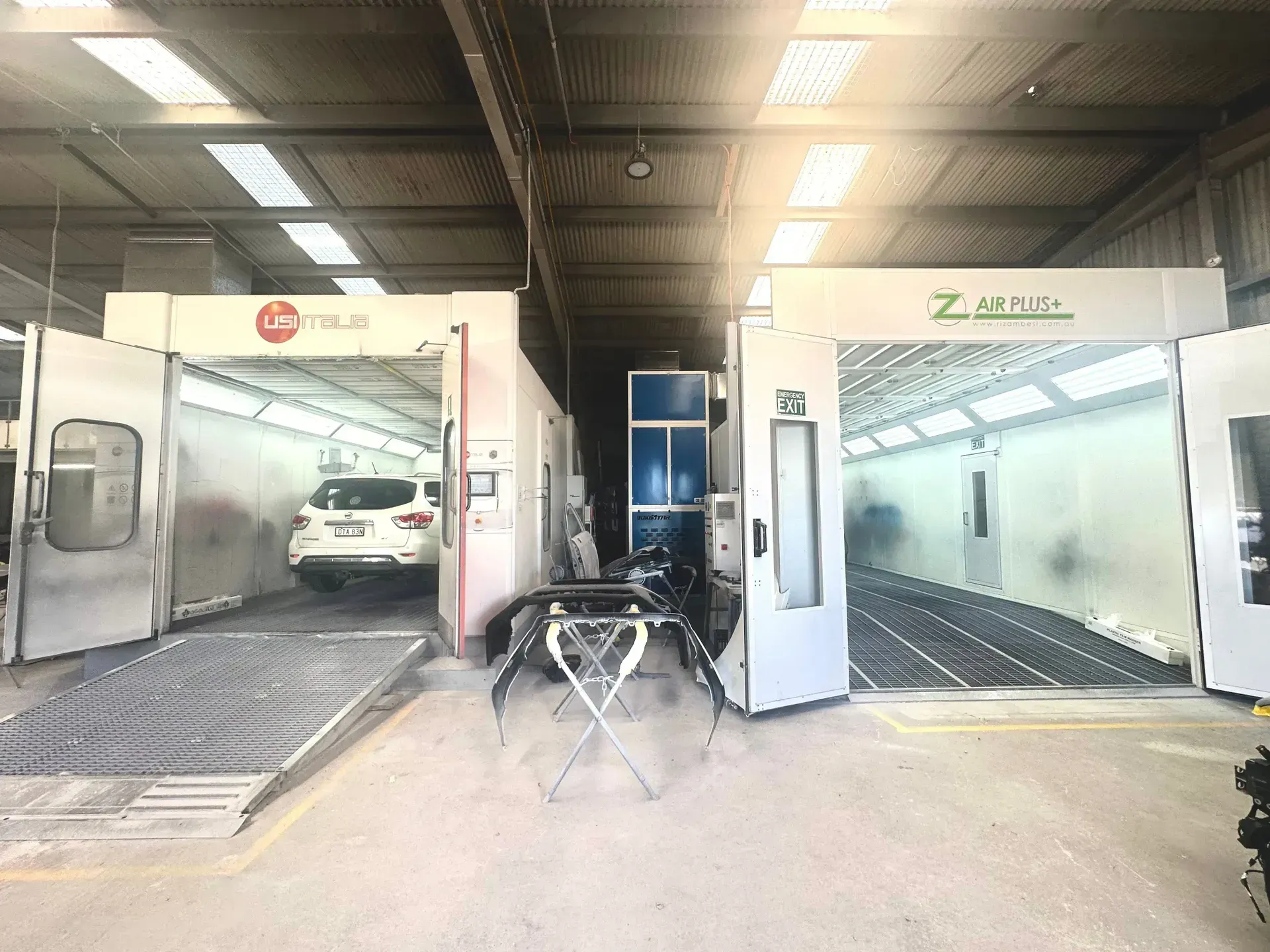Two White Car Wash Bays Inside a Warehouse, With ONE Car Being Washed on the Left — Forster Smash Repairs in Forster, NSW