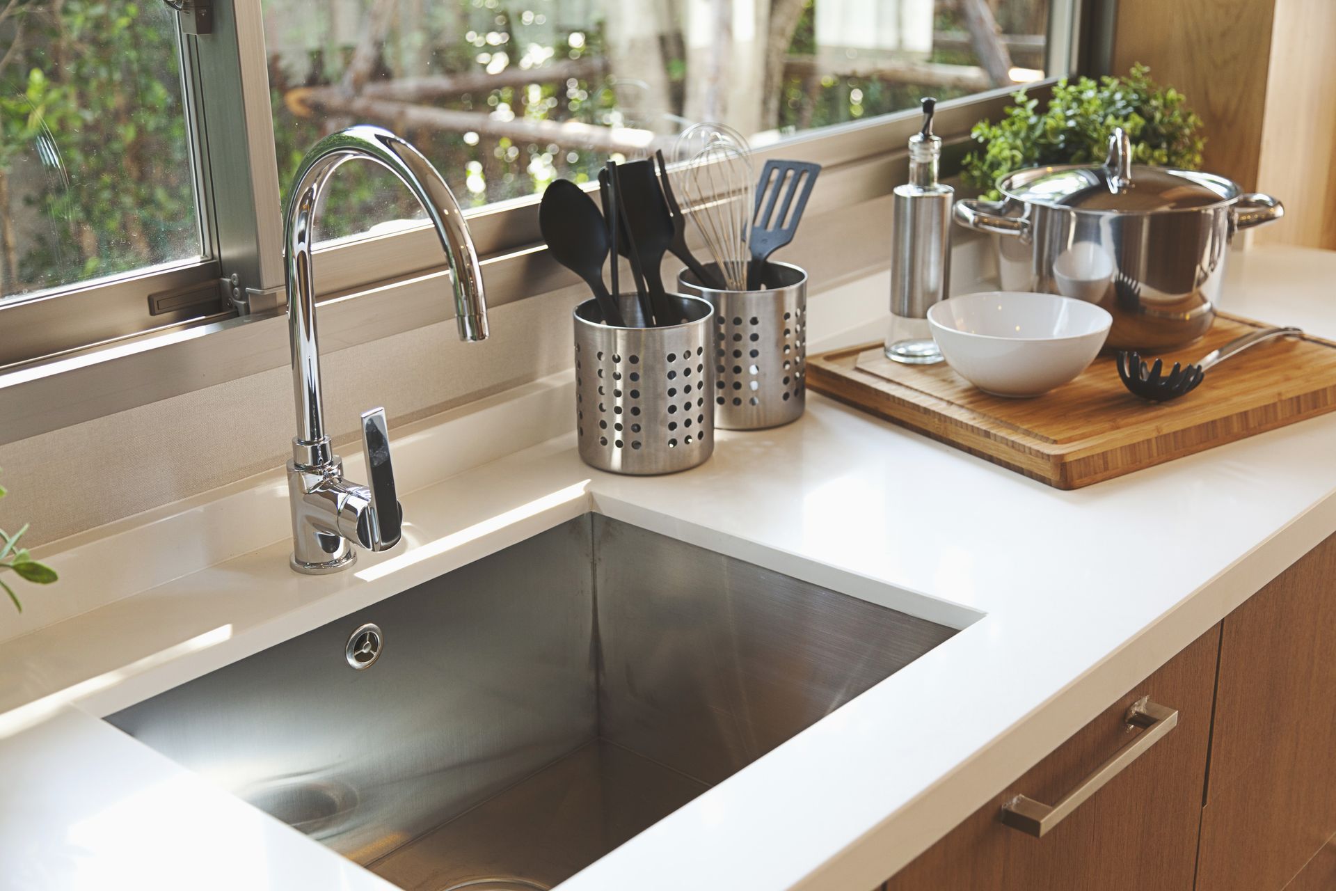 A kitchen with a stainless steel sink and a window.