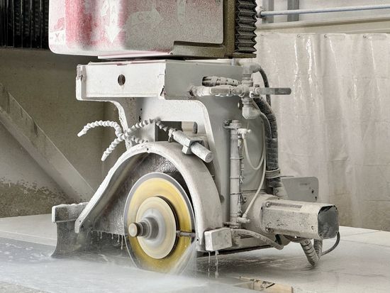 A machine is cutting a piece of concrete in a factory