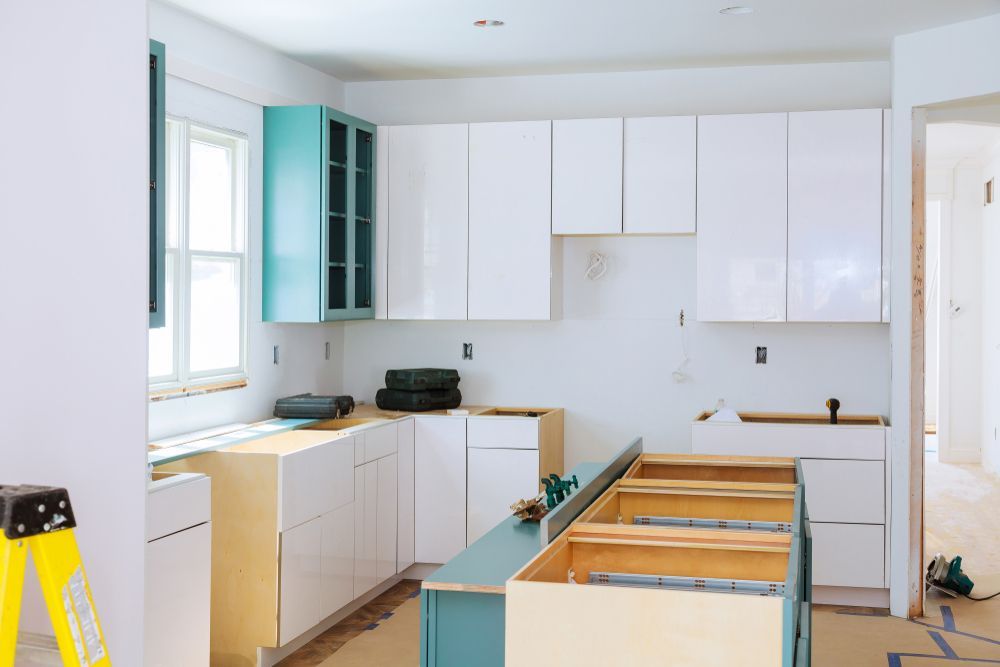 Modern kitchen with wood accent wall, long countertop, and open view to a garden.