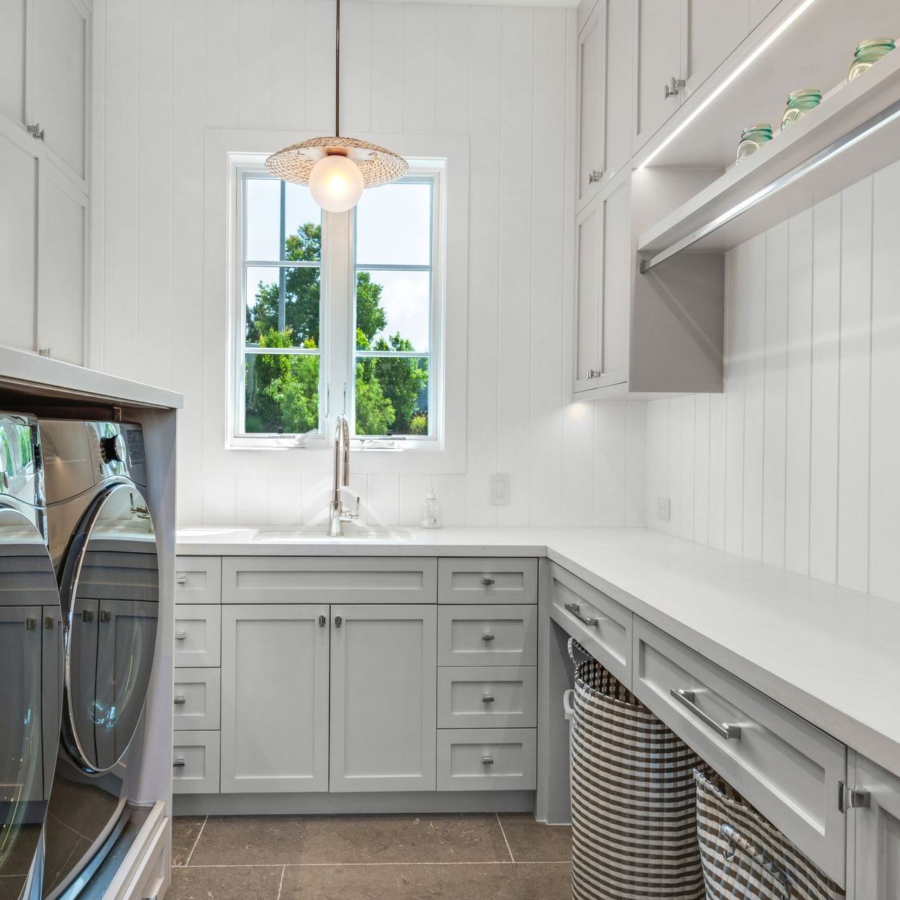 A laundry room with white cabinets and a washer and dryer