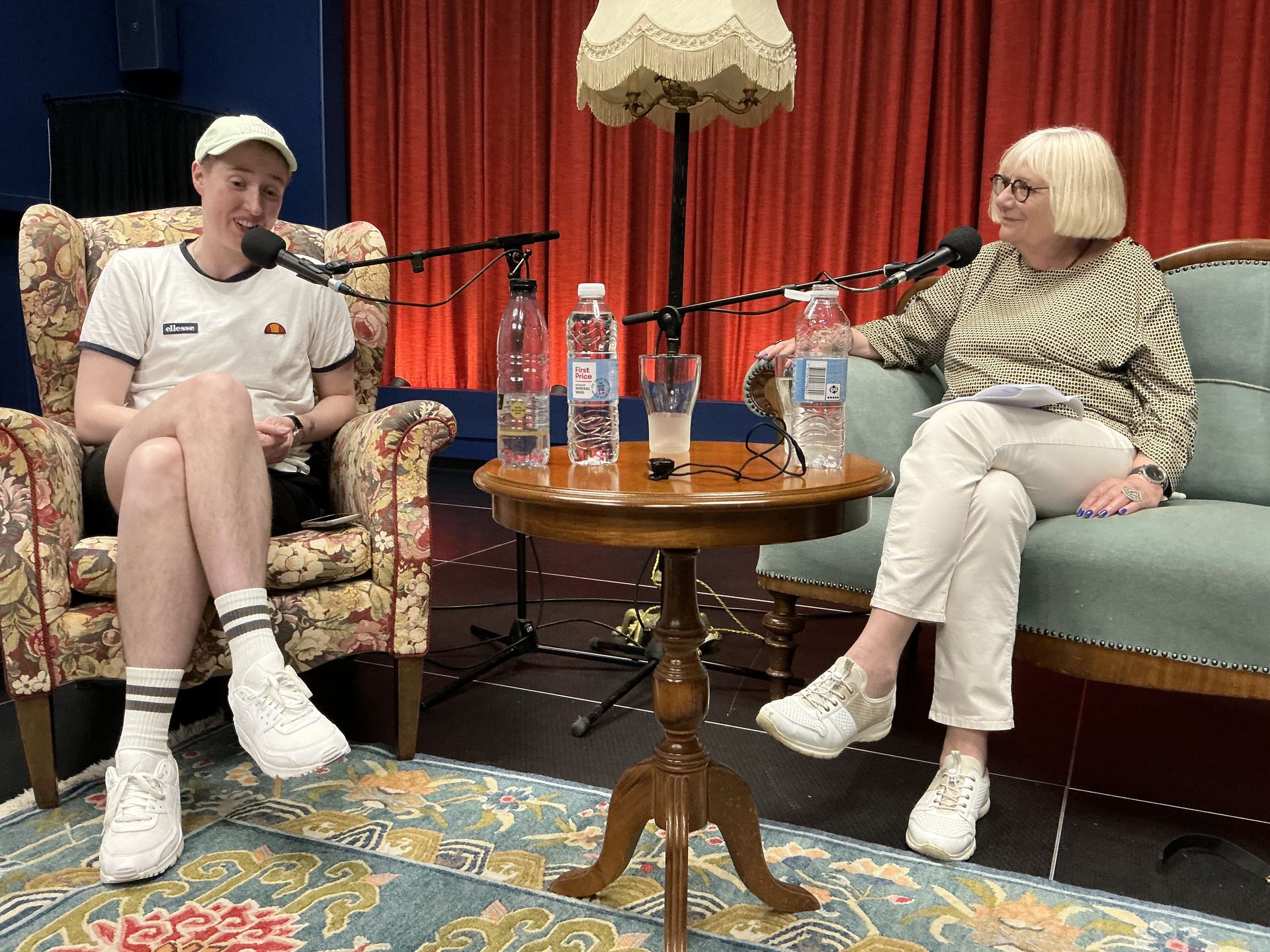 En mand og en kvinde sidder ved et bord med mikrofoner.