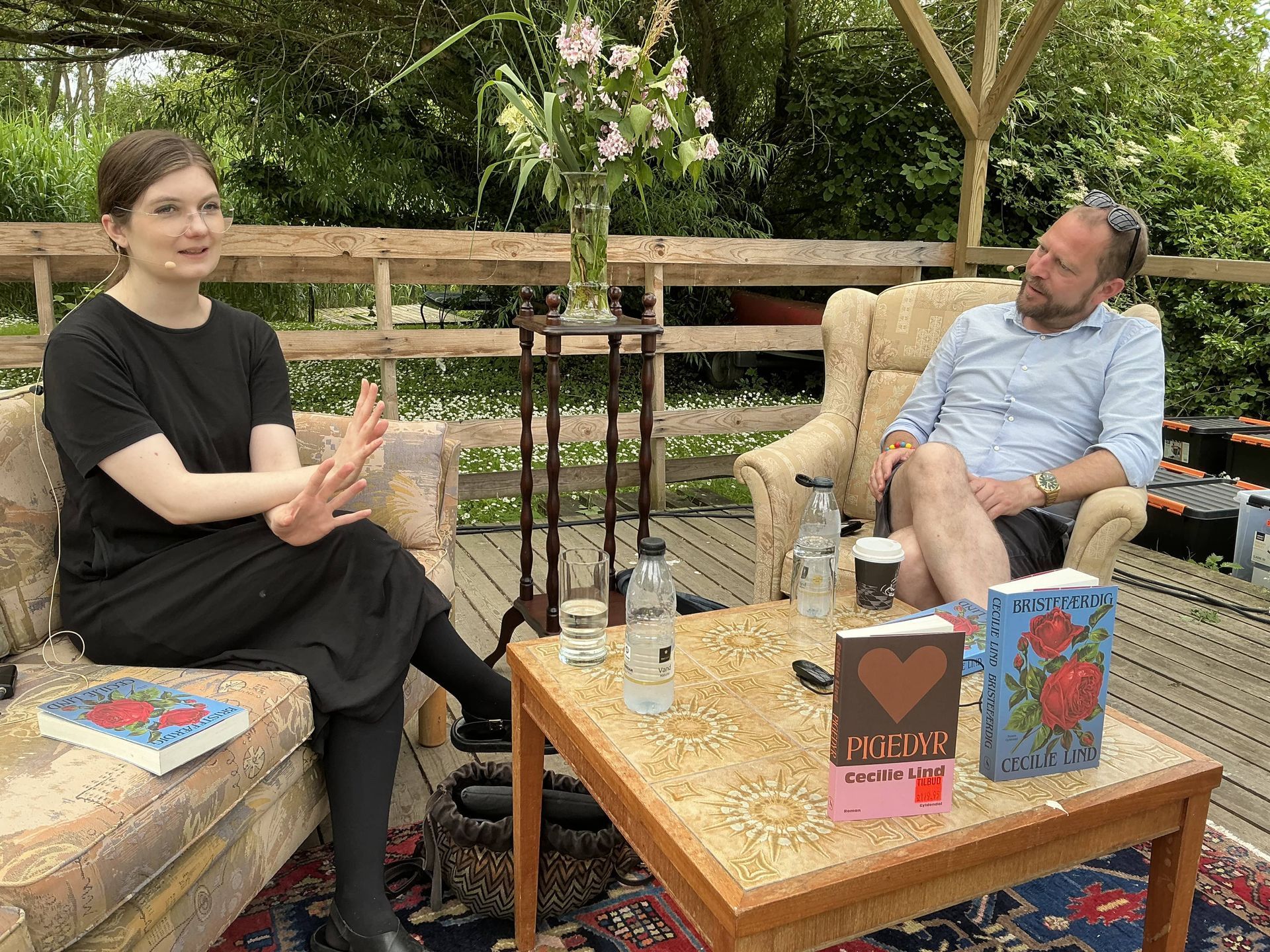 En mand og en kvinde sidder på en sofa og taler med hinanden.