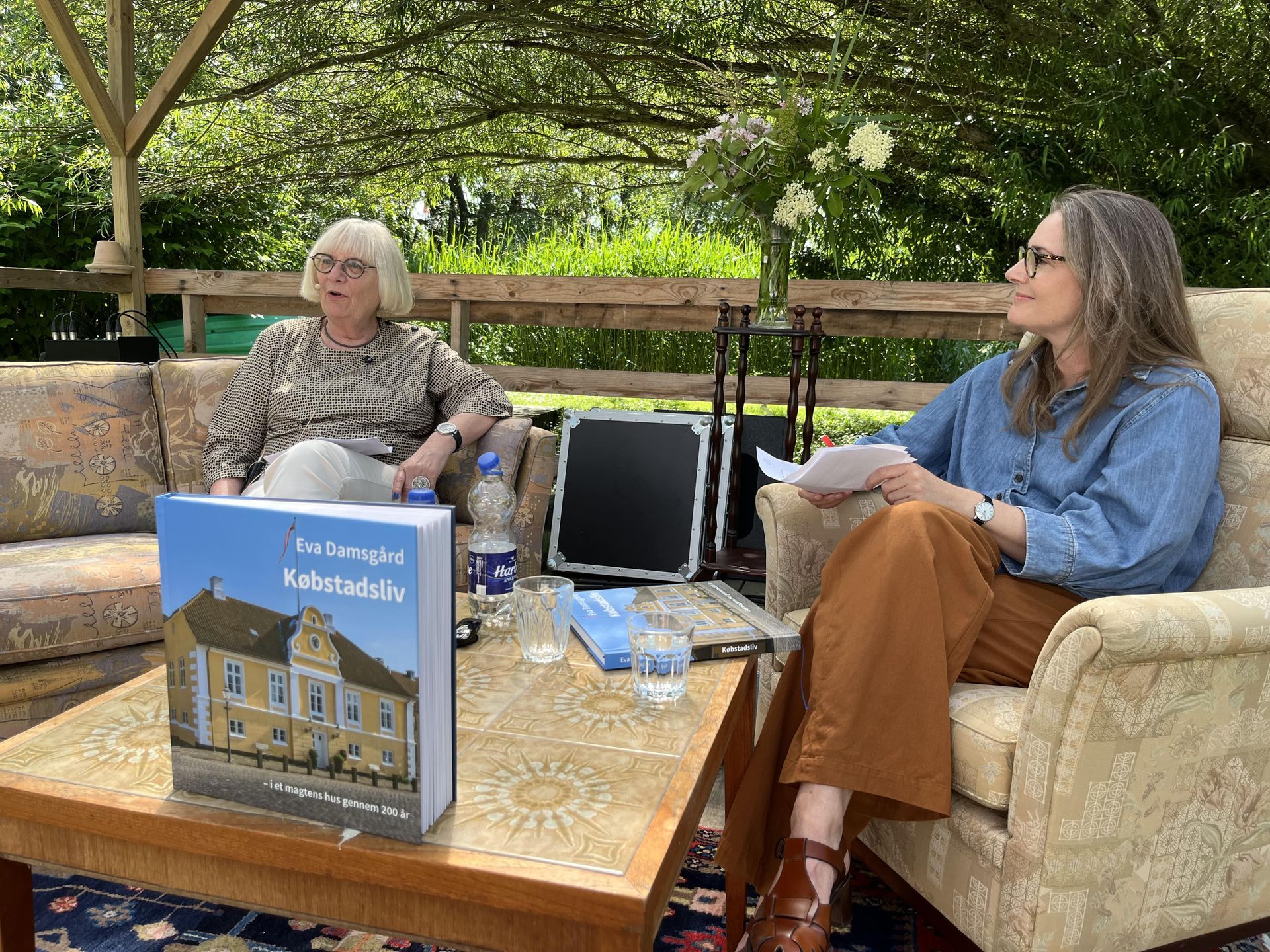 To kvinder sidder ved et bord med en bog på.