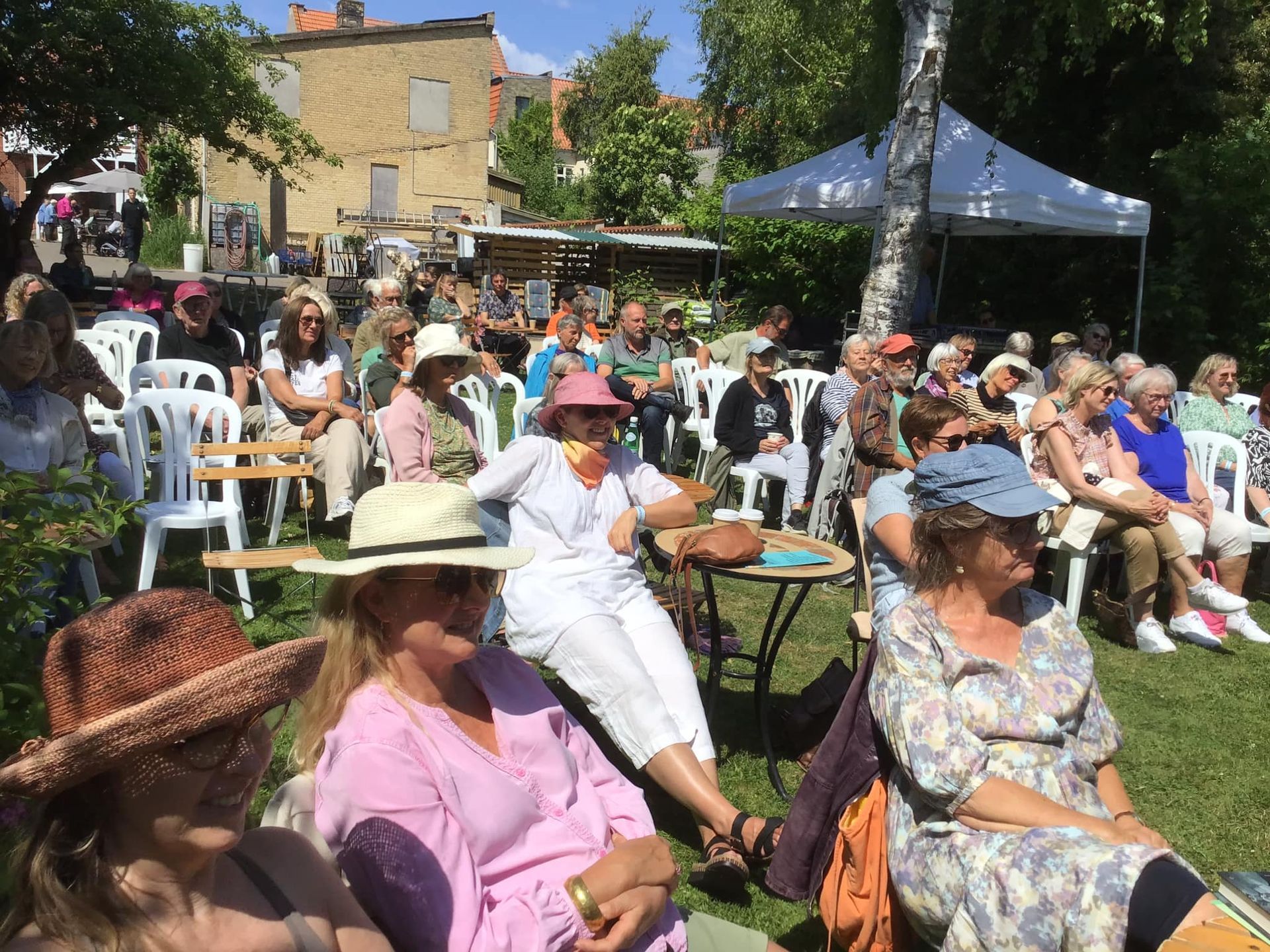 En gruppe mennesker sidder i stole i en park.