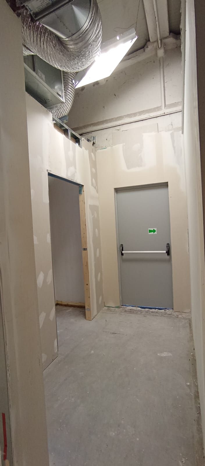 Un corridoio vuoto con una porta e una luce sul soffitto.