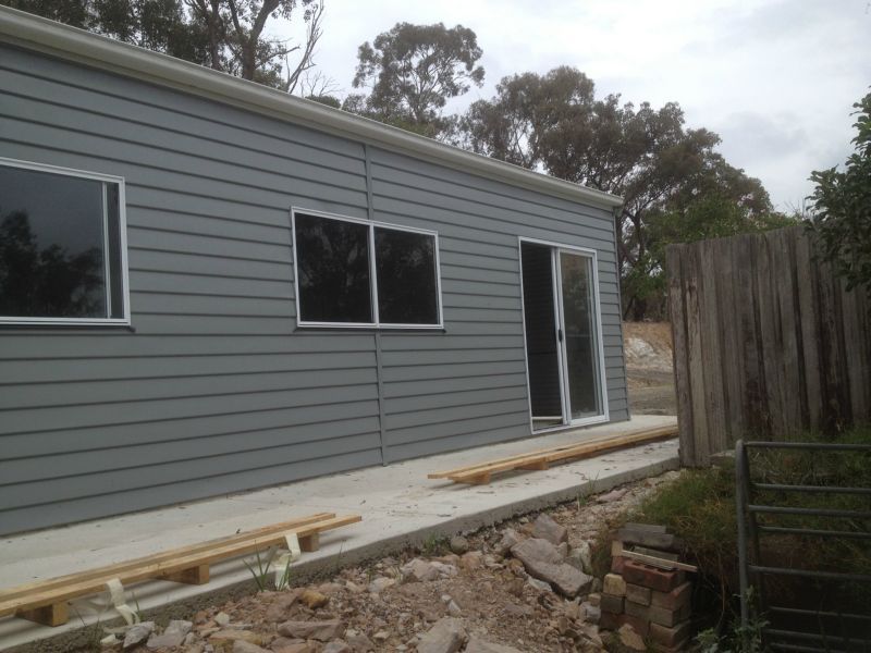 A Gray House with a Lot of Windows and a Sliding Glass Door - Wallan, VIC - Victorian Garages & Barns