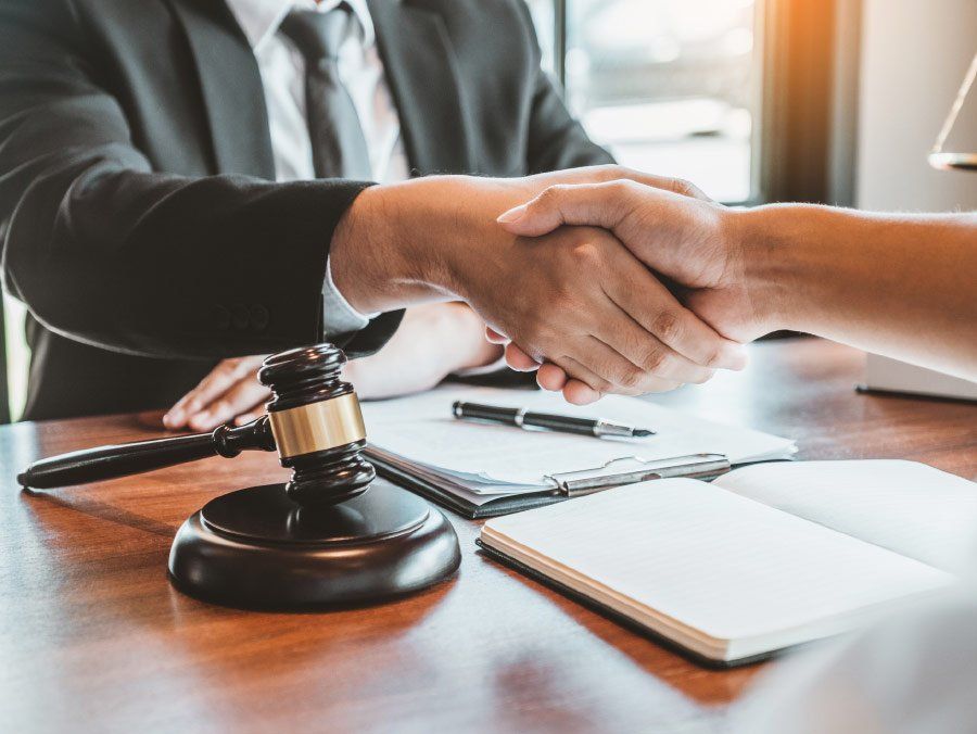 A judge is shaking hands with a client in front of a gavel.