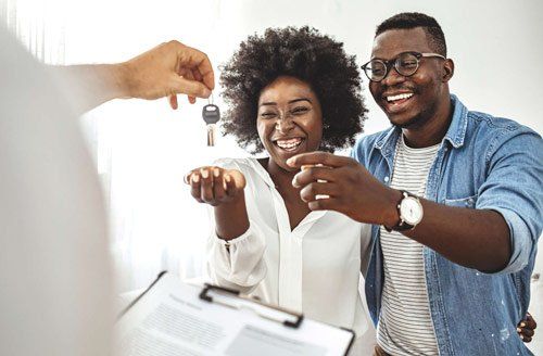 A man is giving a woman the keys to their new home.