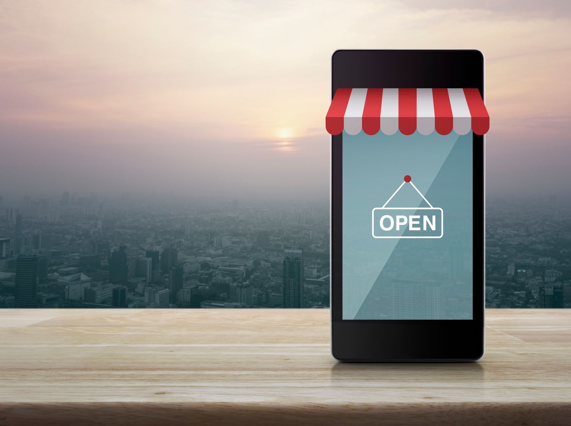 A smart phone with an open sign on the screen is sitting on a wooden table.
