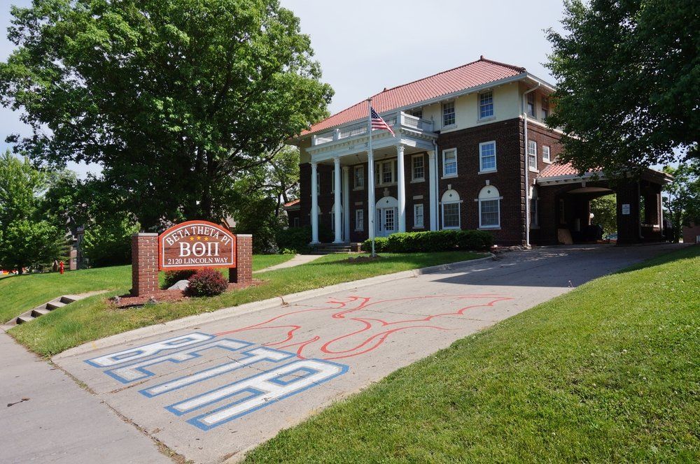 A large building with graffiti on the sidewalk in front of it.