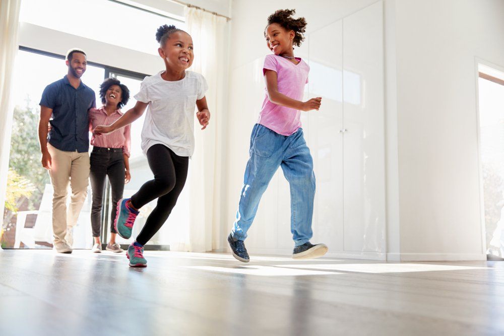 A family is jumping in the air in a living room.