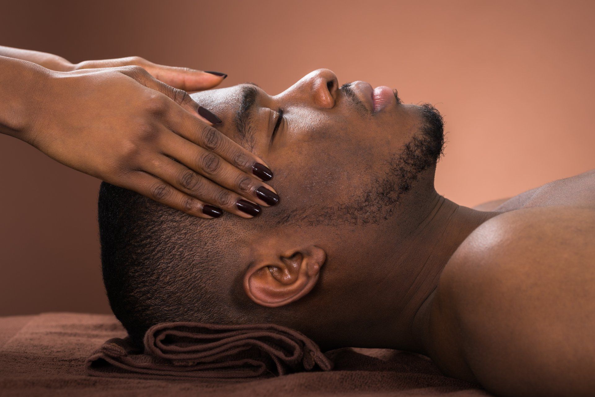 A man is getting a head massage at a spa.