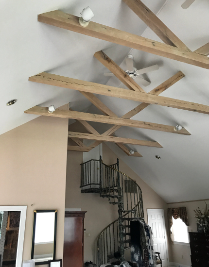 A living room with wooden beams and a spiral staircase