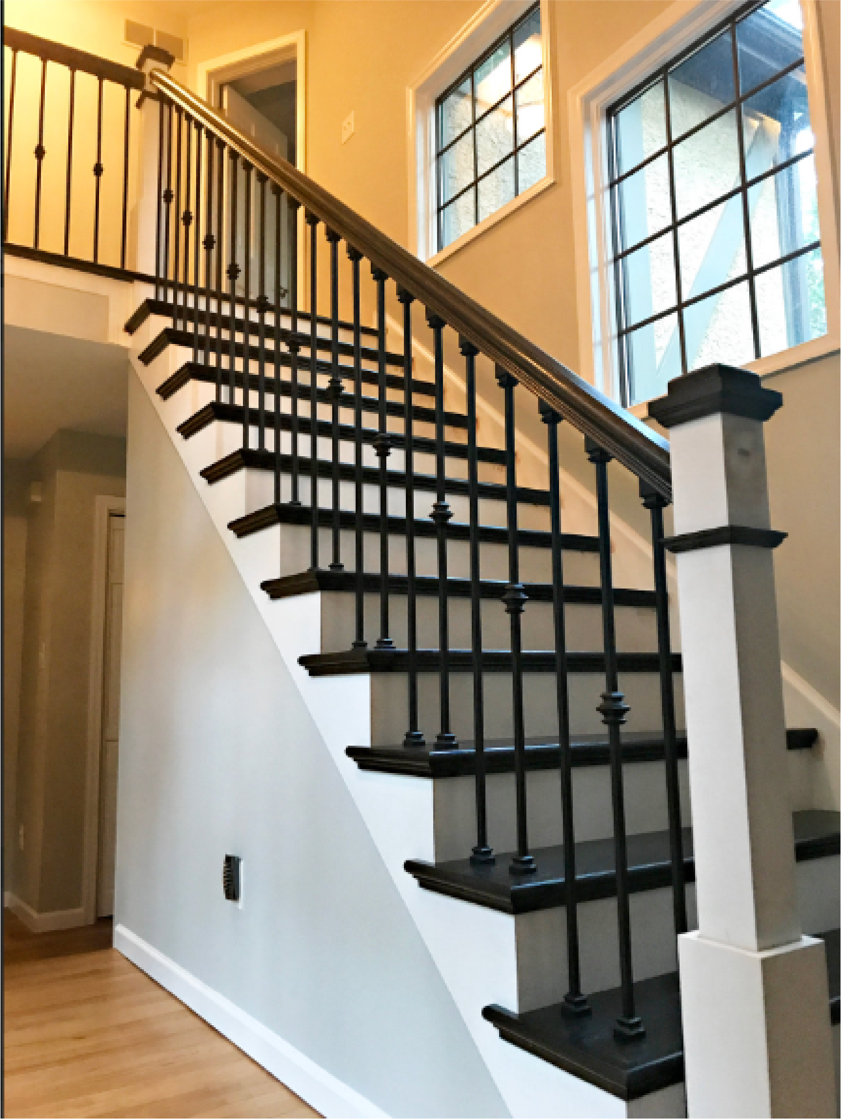 A staircase with a black railing and white steps