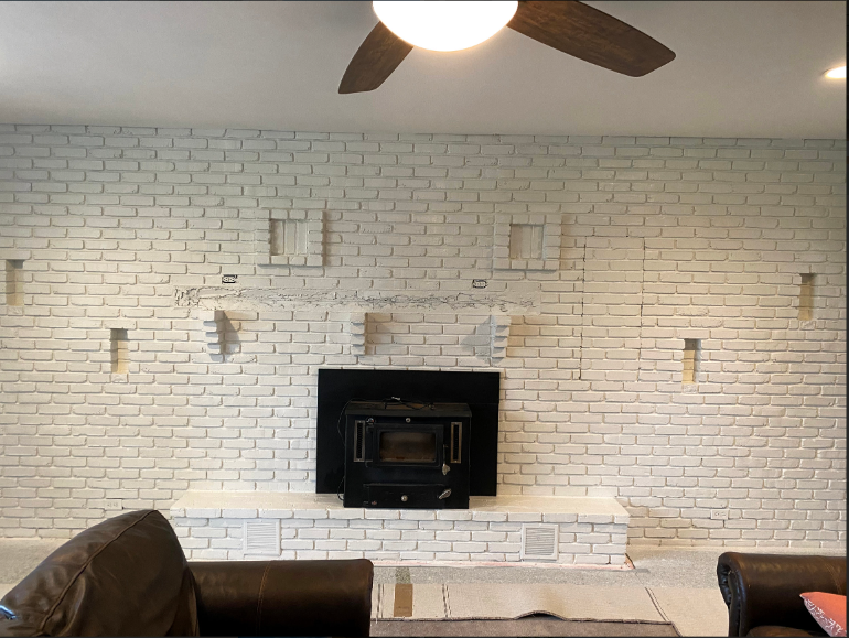 A living room with a fireplace and a ceiling fan